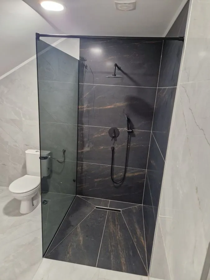 Walk-in tuš kabina po mjeri, fiksna staklena stjenka, parsol sivo kaljeno staklo i crni okov, izrada StakloDom