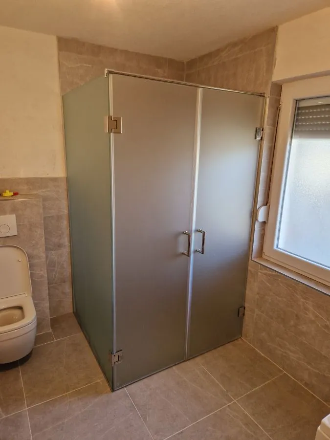 Ugaona tuš kabina po mjeri, postava na L, mliječno pjeskareno staklo i inox okov, izrada StakloDom